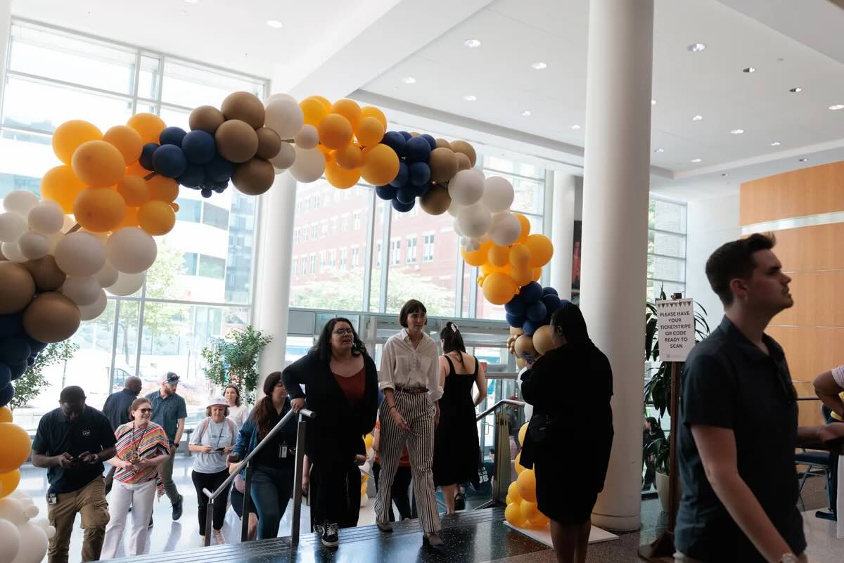 Staff walk under a balloon arch at the entrance to the University Student Center Great Hall