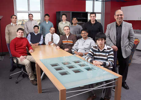 Group of 13 researchers sit at a table
