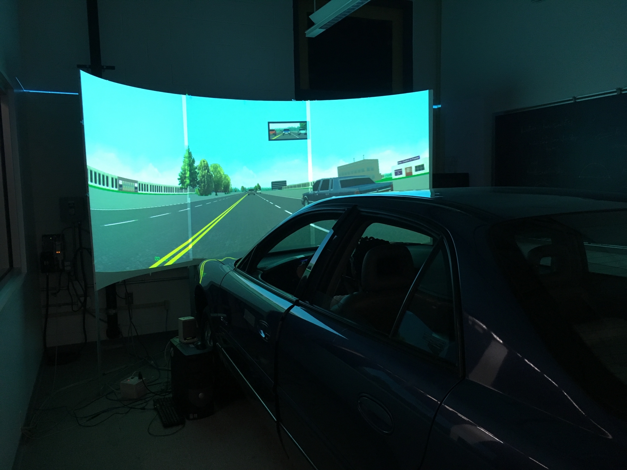 Driving Simulator car in lab with road scene on screen
