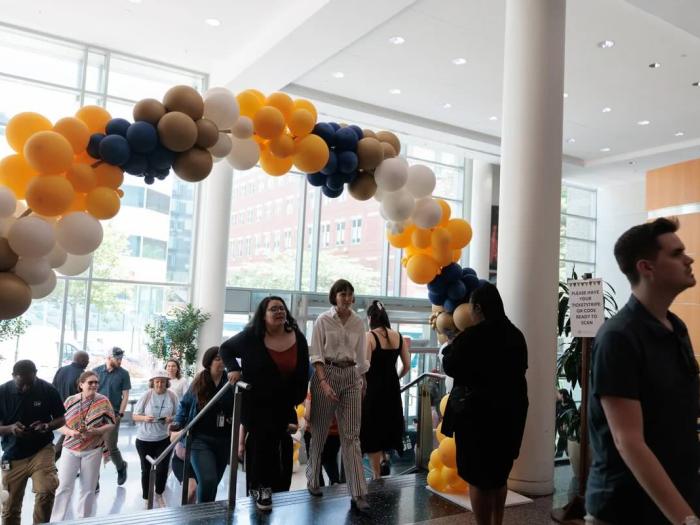Staff walk under a balloon arch at the entrance to the University Student Center Great Hall